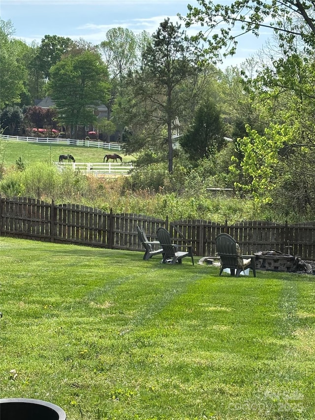view of yard featuring fence and an outdoor fire pit