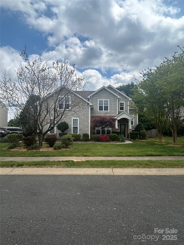 traditional-style house featuring fence and a front yard