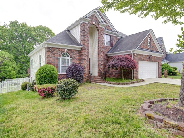 7642 Horseshoe Creek Dr, Huntersville, NC 28078 - traditional-style house featuring concrete driveway, fence, a front yard, a garage, and brick siding