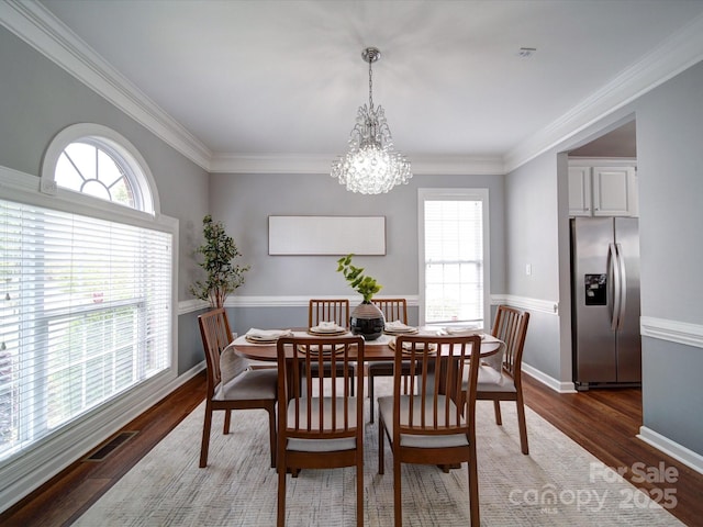 7642 Horseshoe Creek Dr, Huntersville, NC 28078 - dining area featuring an inviting chandelier, wood finished floors, a wealth of natural light, and ornamental molding