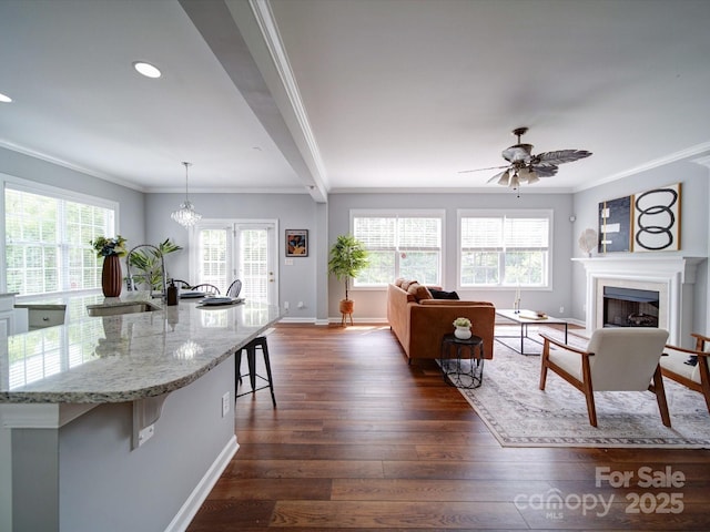 7642 Horseshoe Creek Dr, Huntersville, NC 28078 - living area featuring dark wood-type flooring, crown molding, baseboards, a fireplace, and ceiling fan with notable chandelier