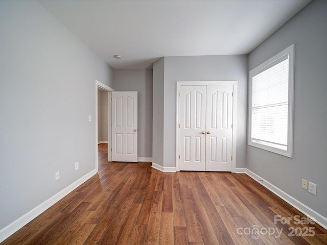 7642 Horseshoe Creek Dr, Huntersville, NC 28078 - unfurnished bedroom featuring wood finished floors, a closet, and baseboards