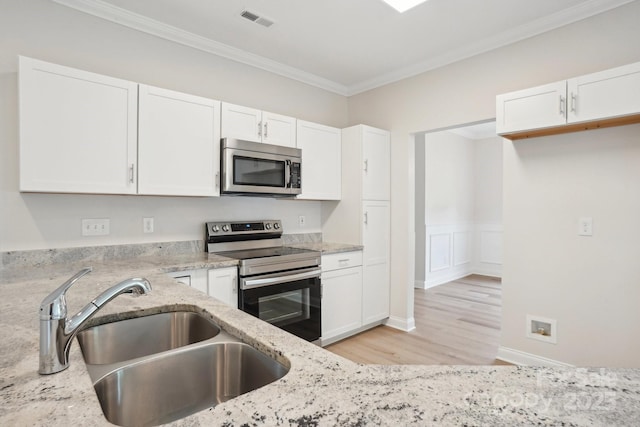 kitchen featuring light stone countertops, stainless steel appliances, visible vents, and a sink