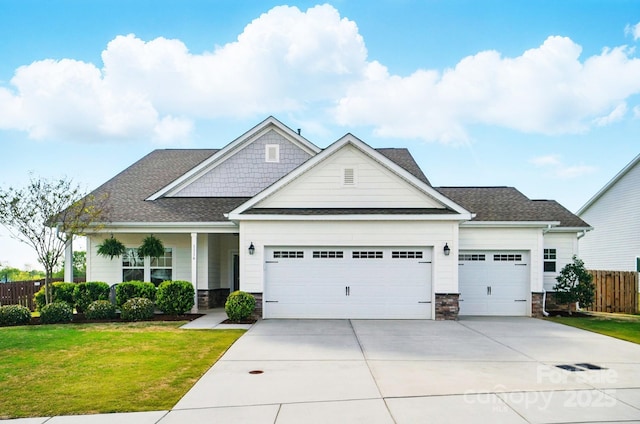 craftsman-style home with stone siding, a front yard, and a garage