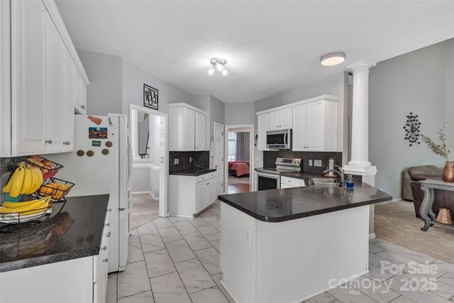 5775 Monticello Dr NW, Concord, NC 28027 - kitchen featuring appliances with stainless steel finishes, a sink, a peninsula, marble finish floor, and ornate columns