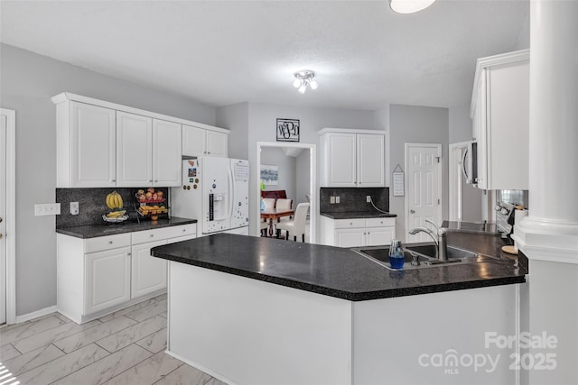 5775 Monticello Dr NW, Concord, NC 28027 - kitchen with dark countertops, white fridge with ice dispenser, a peninsula, and marble finish floor