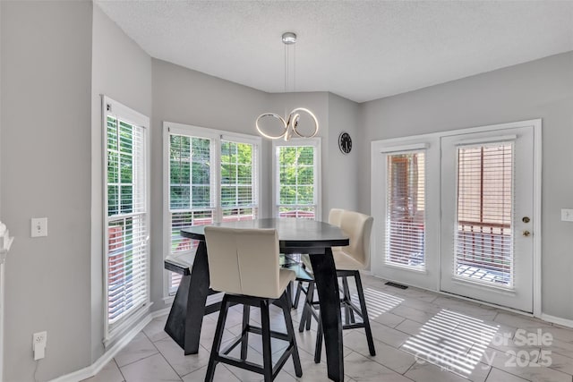 5775 Monticello Dr NW, Concord, NC 28027 - dining space with visible vents, a textured ceiling, baseboards, and a notable chandelier