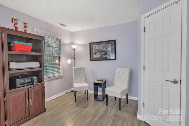 5775 Monticello Dr NW, Concord, NC 28027 - sitting room featuring visible vents, a textured ceiling, light wood-style flooring, and baseboards