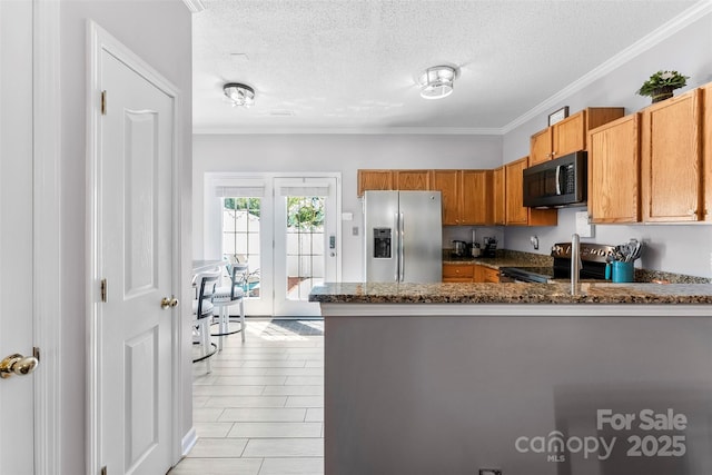8814 Gerren Ct, Charlotte, NC 28217 - kitchen with dark stone counters, stainless steel appliances, a peninsula, and a textured ceiling