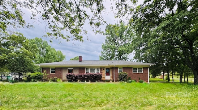 single story home featuring a chimney, a front lawn, brick siding, and fence
