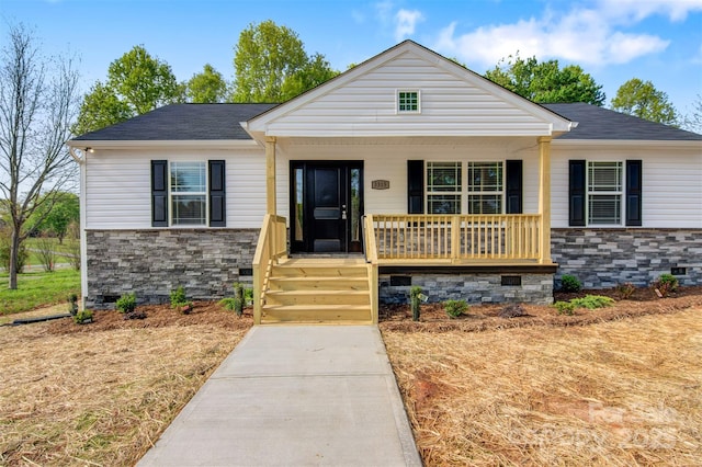 view of front of property featuring a porch, a shingled roof, crawl space, and stone siding