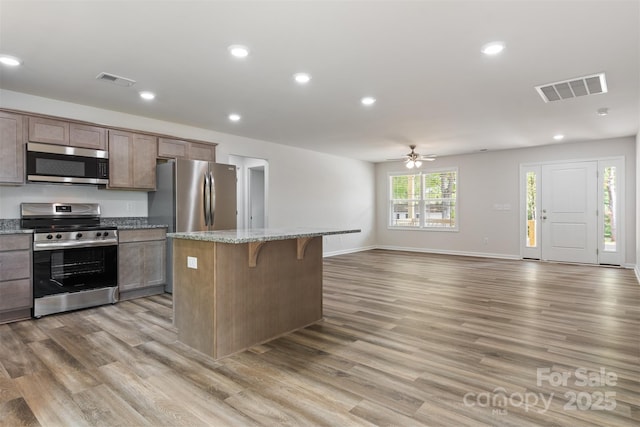 kitchen with visible vents, a ceiling fan, appliances with stainless steel finishes, and light wood-type flooring