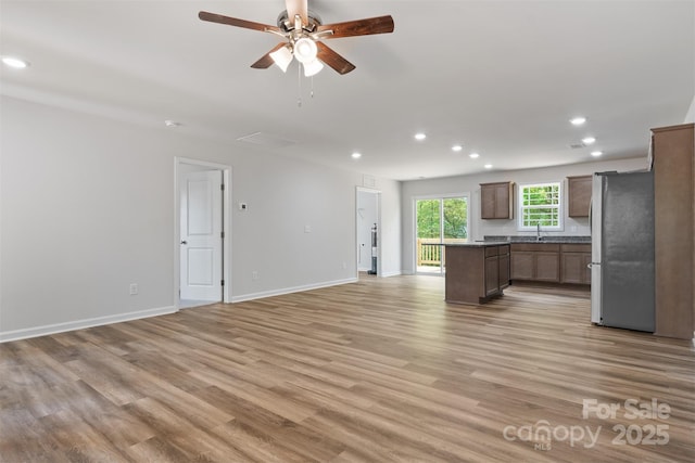unfurnished living room with light wood-style flooring, recessed lighting, baseboards, a ceiling fan, and visible vents