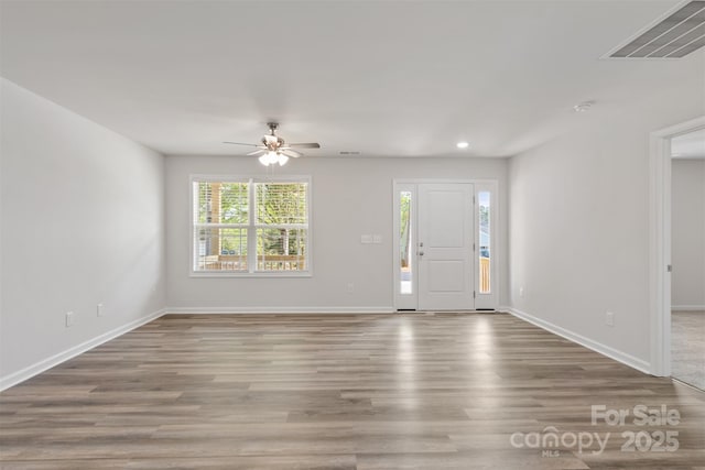 foyer with visible vents, baseboards, ceiling fan, and wood finished floors