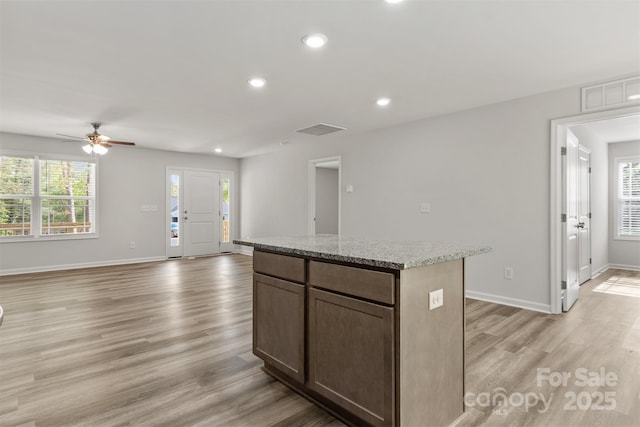 kitchen with recessed lighting, ceiling fan, a center island, and light wood-type flooring