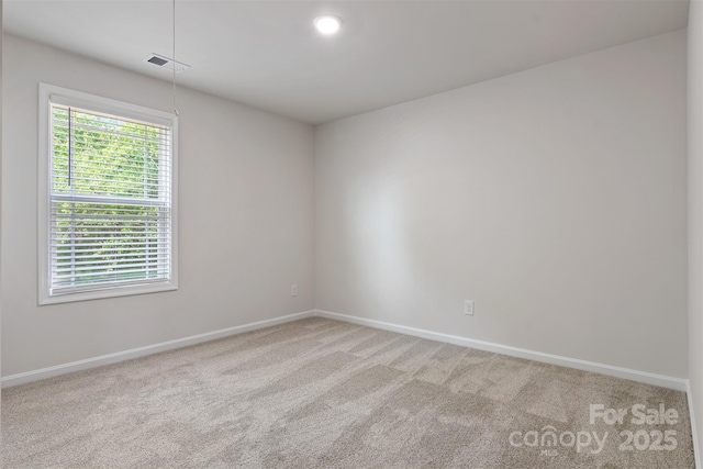 unfurnished room featuring baseboards, carpet flooring, and visible vents