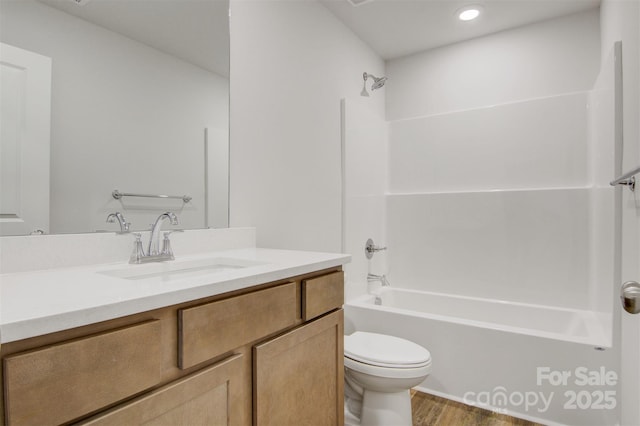 full bath with toilet, shower / tub combination, wood finished floors, and vanity