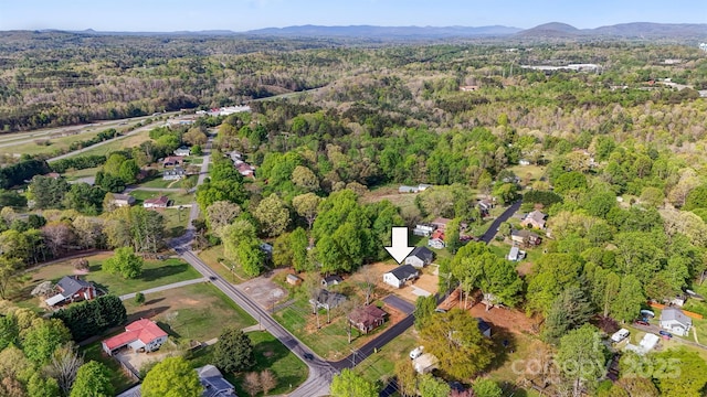 birds eye view of property featuring a view of trees and a mountain view