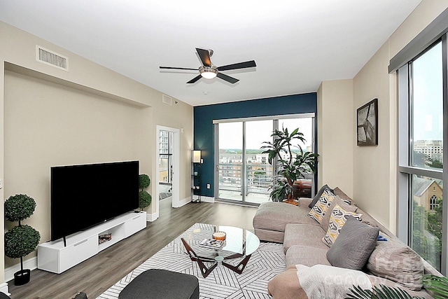 living area with ceiling fan, visible vents, and wood finished floors