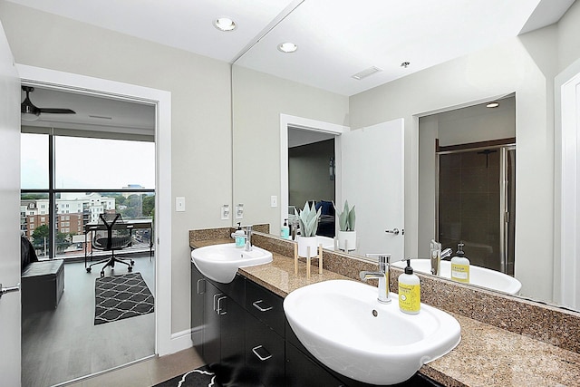 full bath with a sink, a shower stall, recessed lighting, and double vanity