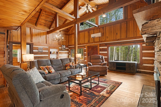 living area with plenty of natural light, wood walls, and high vaulted ceiling