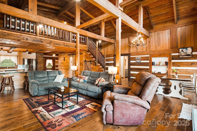 living room featuring wood ceiling, wood walls, a chandelier, and beam ceiling