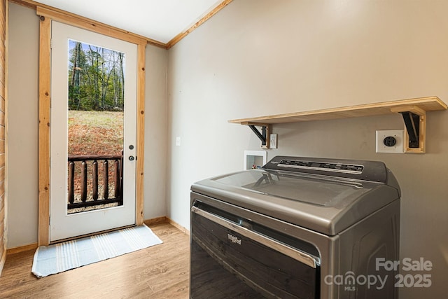 clothes washing area with light wood-style flooring, washer / clothes dryer, baseboards, ornamental molding, and laundry area