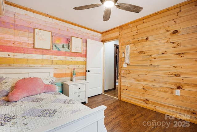 bedroom featuring ceiling fan, wooden walls, and dark wood-type flooring