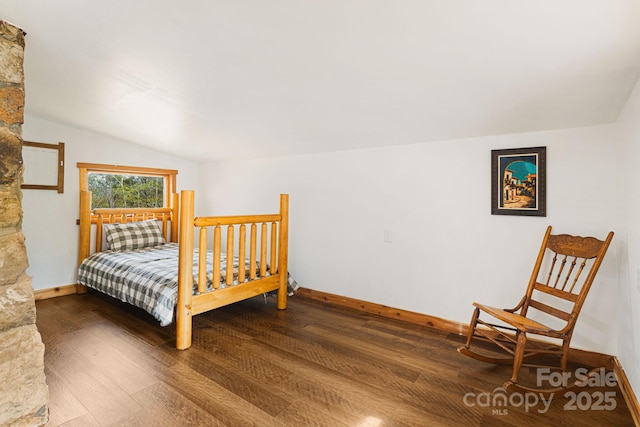 bedroom with wood finished floors, vaulted ceiling, and baseboards