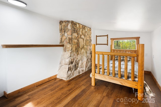 bedroom with baseboards and wood finished floors