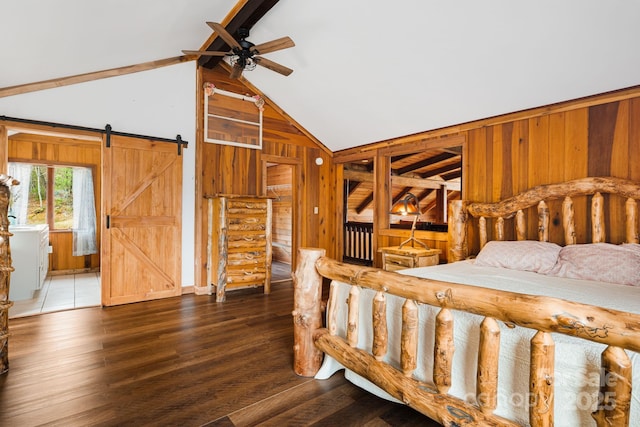 bedroom with high vaulted ceiling, a barn door, wood finished floors, wooden walls, and beam ceiling
