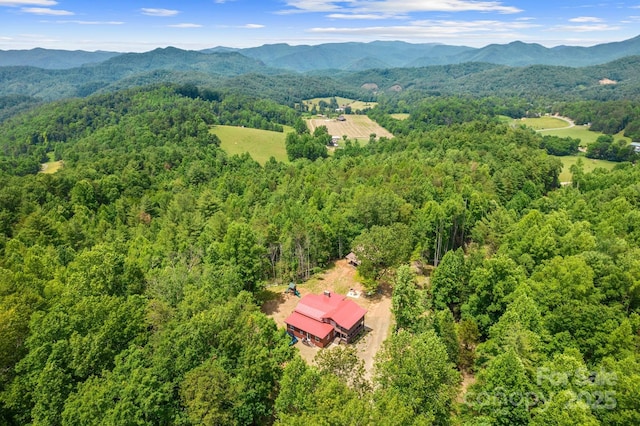 drone / aerial view featuring a wooded view and a mountain view