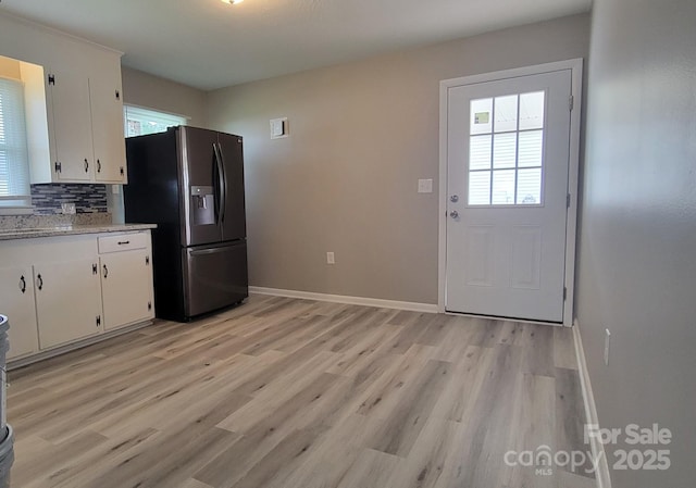kitchen with stainless steel fridge with ice dispenser, light wood finished floors, and plenty of natural light