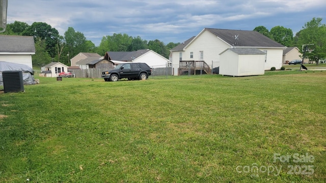 view of yard featuring fence, a shed, and an outbuilding