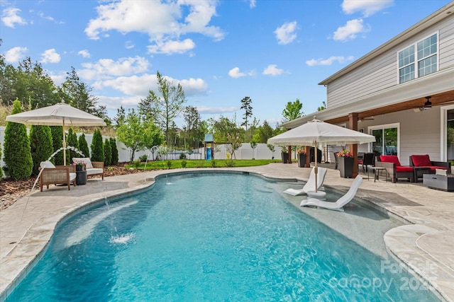 view of swimming pool with a patio, a fenced in pool, a fenced backyard, a ceiling fan, and an outdoor hangout area