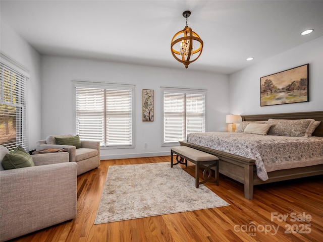 bedroom with a chandelier, recessed lighting, and wood finished floors