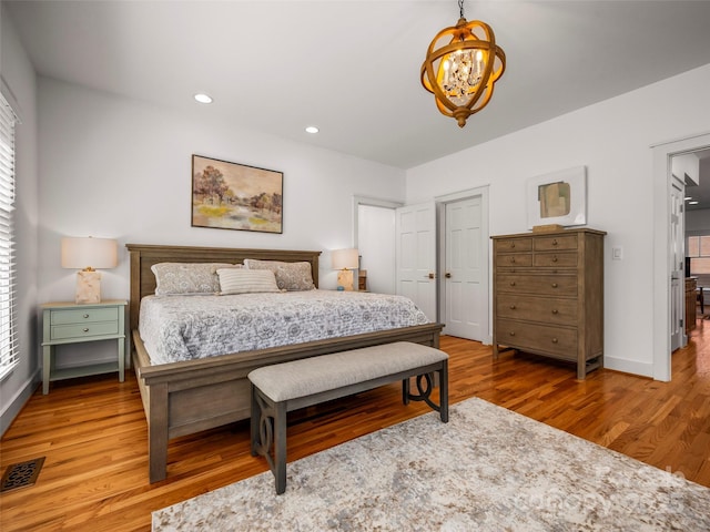 bedroom featuring recessed lighting, a chandelier, light wood-type flooring, baseboards, and visible vents
