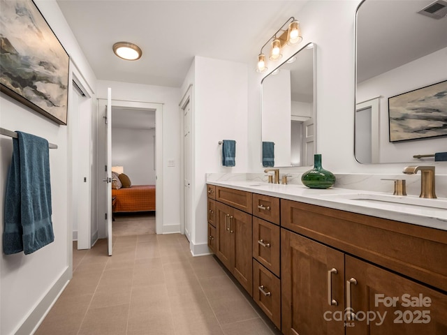 full bathroom featuring a sink, double vanity, visible vents, baseboards, and ensuite bath