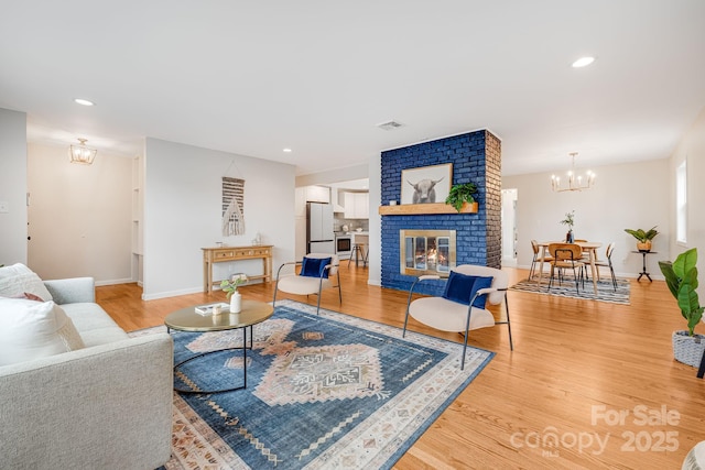 16 Graystone Rd, Asheville, NC 28804 - living area with an inviting chandelier, visible vents, a brick fireplace, wood finished floors, and baseboards