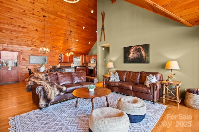 living room featuring vaulted ceiling, a chandelier, wood ceiling, light wood finished floors, and wood walls