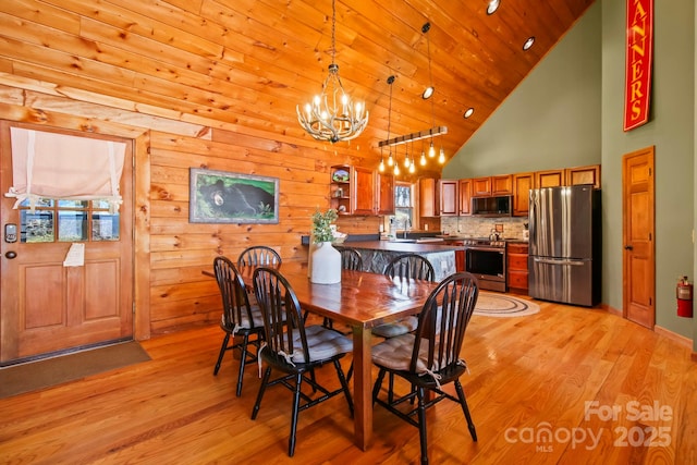 dining area with an inviting chandelier, wooden ceiling, baseboards, light wood-style flooring, and high vaulted ceiling