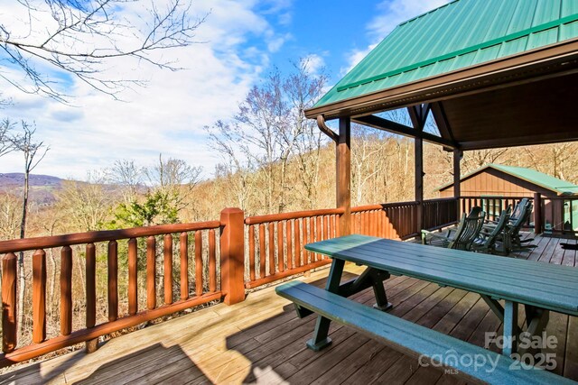 deck with outdoor dining area and a mountain view