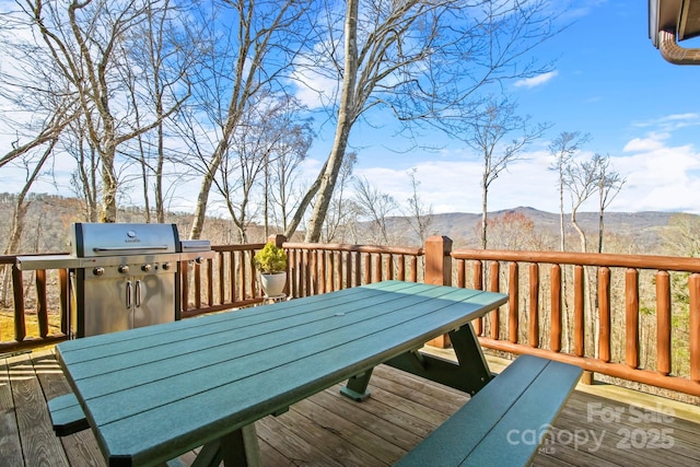 wooden deck featuring outdoor dining area, a mountain view, and grilling area