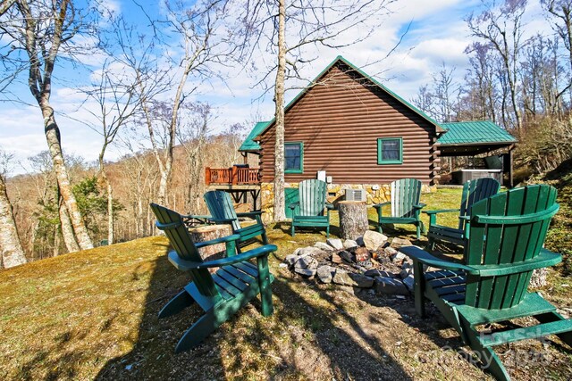 exterior space with a fire pit and log siding