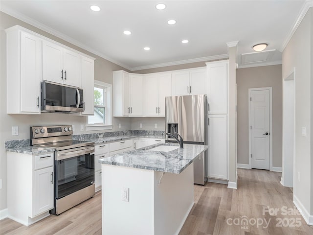 21 Kathy Dr, Waynesville, NC 28786 - kitchen with appliances with stainless steel finishes, a sink, light wood-type flooring, a kitchen island with sink, and white cabinetry