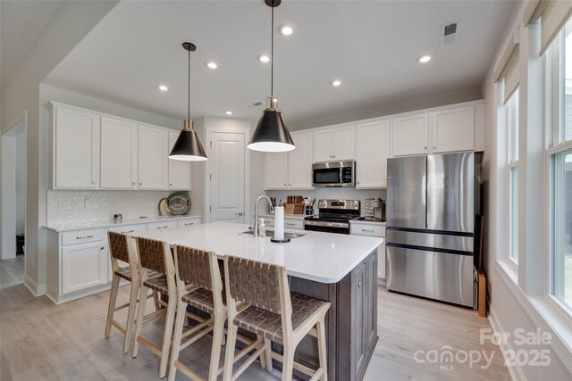 3029 Trace Meadow Ct, York, SC 29745 - kitchen featuring an island with sink, a sink, appliances with stainless steel finishes, visible vents, and light wood-style floors