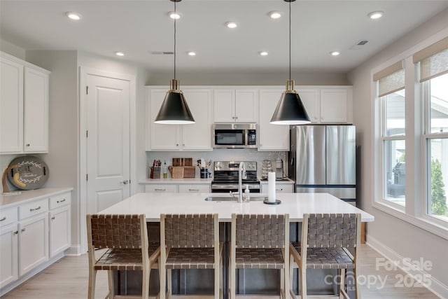 3029 Trace Meadow Ct, York, SC 29745 - kitchen with a sink, stainless steel appliances, a breakfast bar, white cabinetry, and decorative backsplash