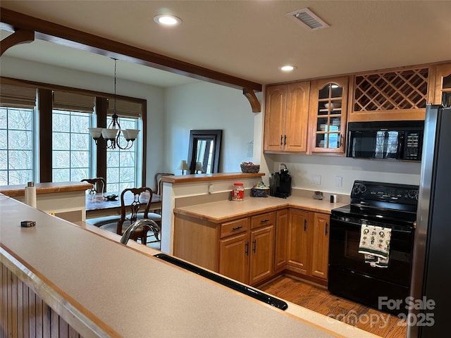 222 Creekside Way, Burnsville, NC 28714 - kitchen with black appliances, wood finished floors, recessed lighting, glass insert cabinets, and a chandelier