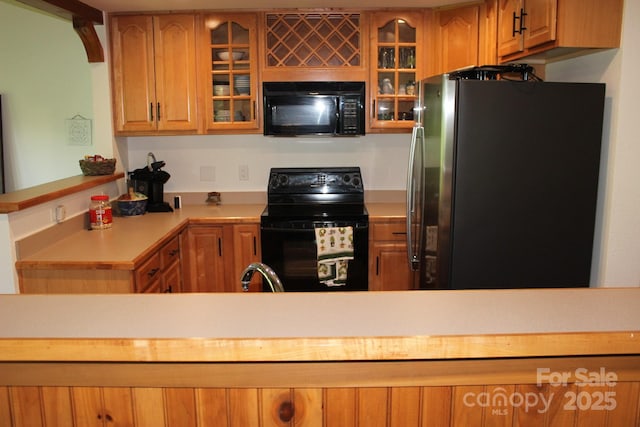 222 Creekside Way, Burnsville, NC 28714 - kitchen featuring black appliances, light countertops, a peninsula, and glass insert cabinets