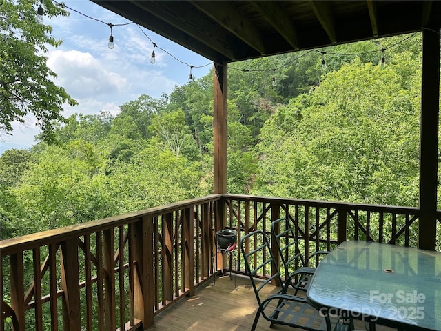222 Creekside Way, Burnsville, NC 28714 - balcony featuring a wooded view and outdoor dining space